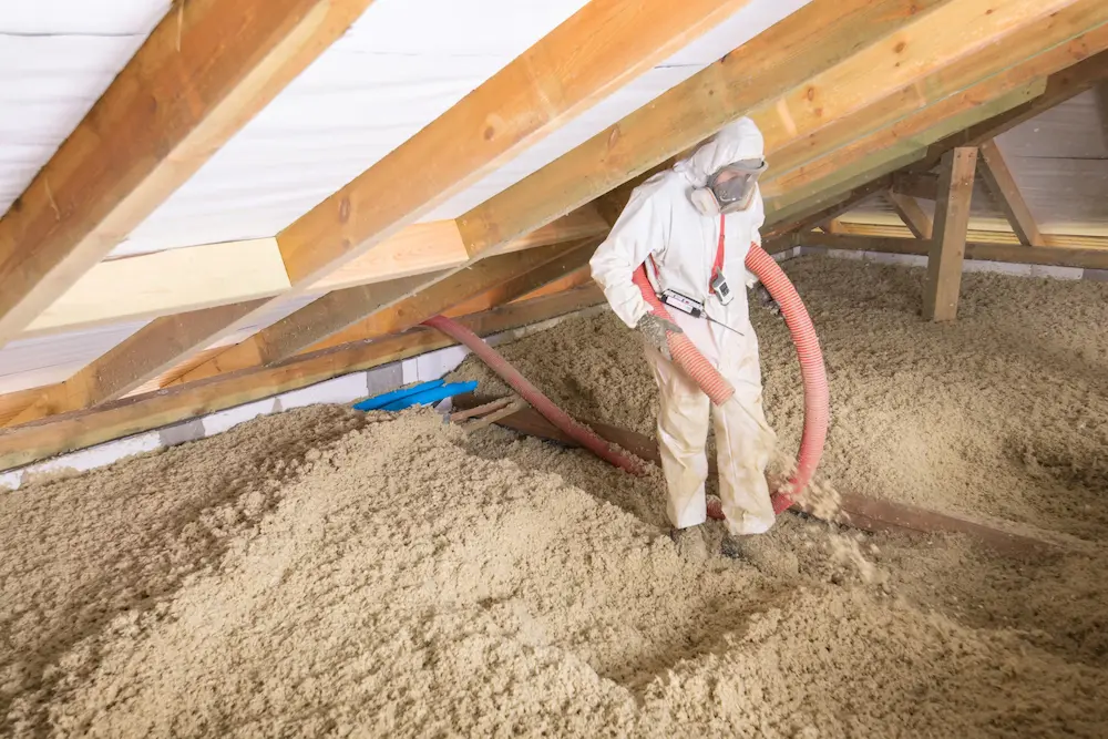 Pracownik wykonujący nadmuch granulatu Granrock Super na poddaszu